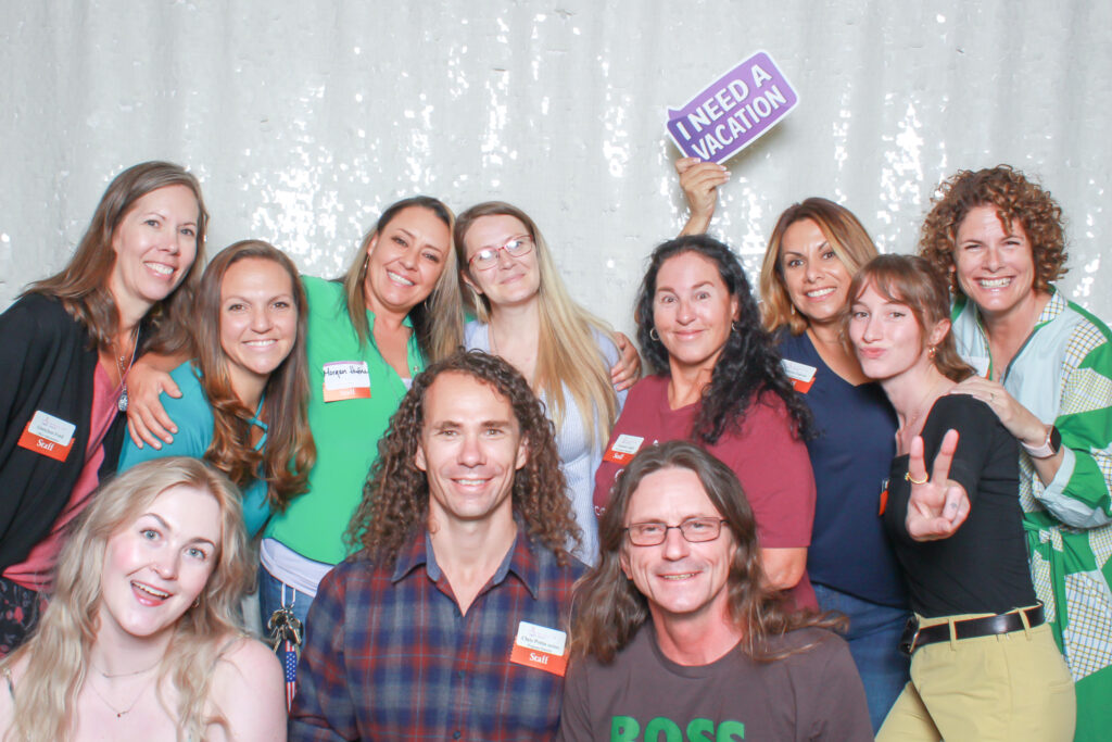 Our Team: Recovery Café Longmont staff smiling together at a community celebration, showing connection, joy, and teamwork.