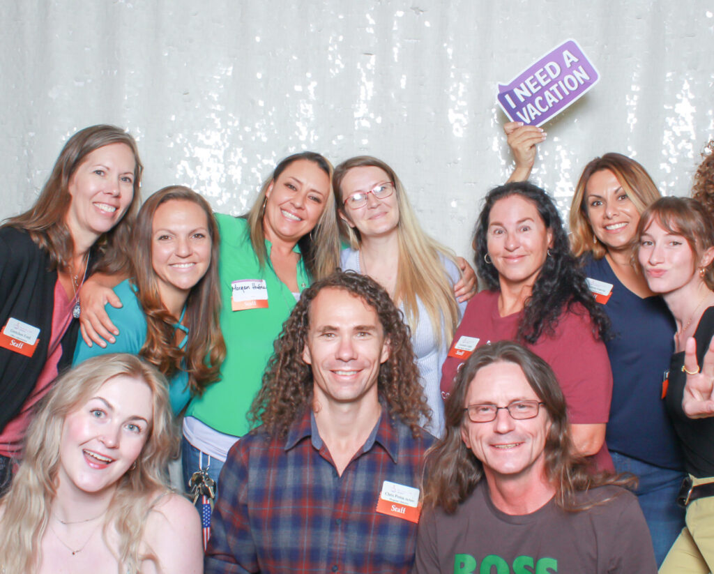 Our Team: Recovery Café Longmont staff smiling together at a community celebration, showing connection, joy, and teamwork.