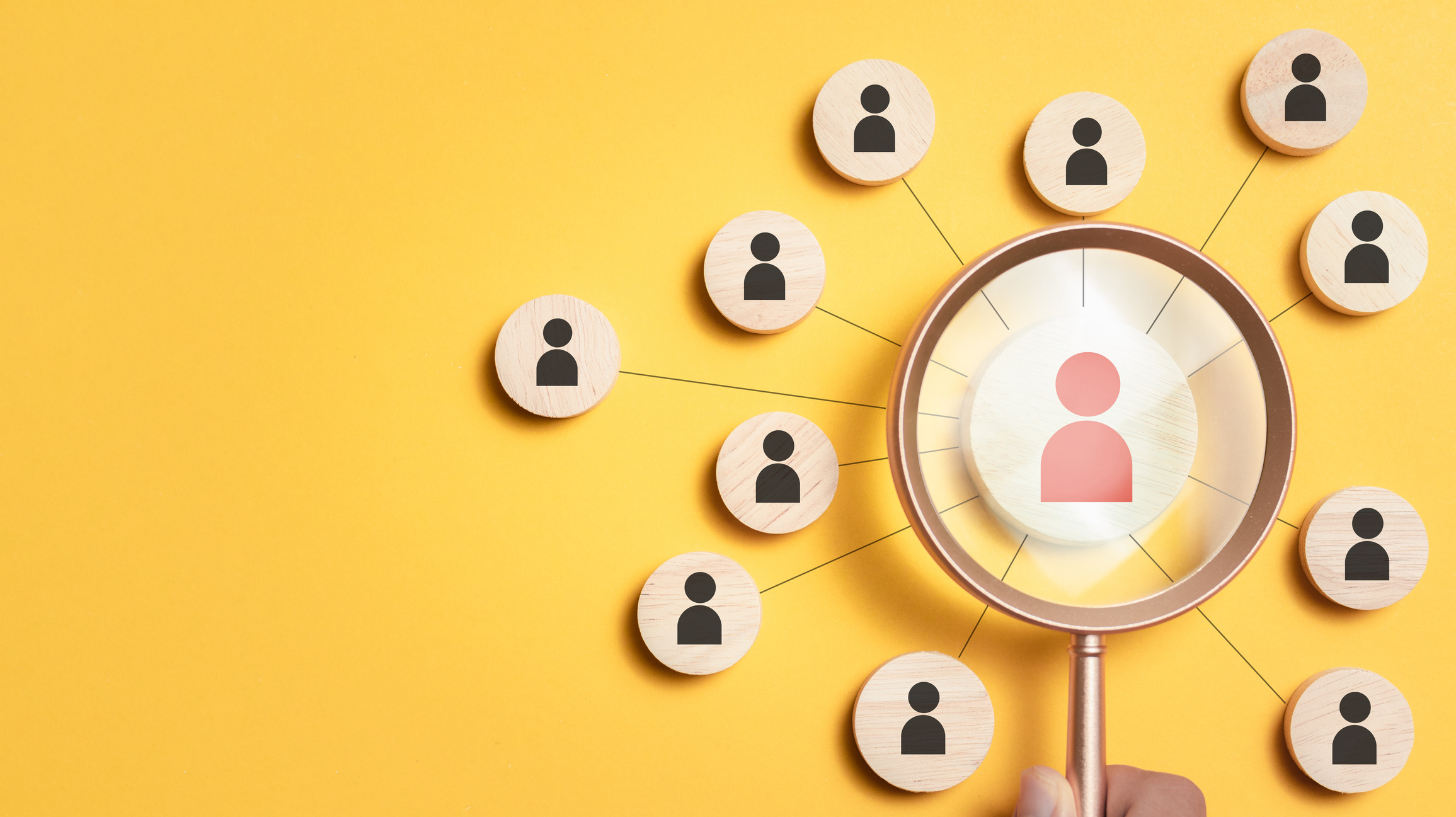 A magnifying glass overlooks many icons of people, representing a job search. It features a yellow background to exude excitement and energy towards the search for a new Executive Director.