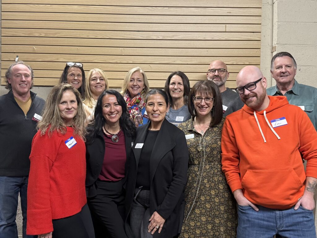 Recovery Café Longmont's board smiles and come together to celebrate recovery and community.